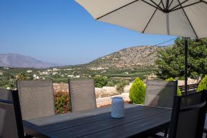 einen Tisch mit einem Sonnenschirm und Stühlen mit Aussicht in der Unterkunft Aerino in Chania