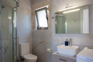 a bathroom with a sink and a toilet and a mirror at Aerino in Chania