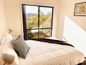 a bedroom with a bed and a large window at Bays Rest in St Helens