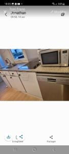 a picture of a kitchen with a microwave on a counter at Mobil home in Fréjus