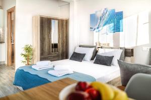een slaapkamer met een groot wit bed en een tafel bij Holiday House Heraklion & Roof Garden in Heraklion
