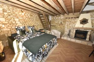 a bedroom with a bed and a stone wall at Maisonnette du bonheur - Vue campagne - Baignoire Balnéo 32 jets - Lits Queen size in Vadencourt-et-Bohéries