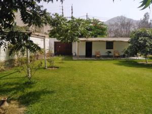 謝內吉亞區的住宿－Casa de campo en Cieneguilla con Piscina，一个带房子和桌椅的庭院