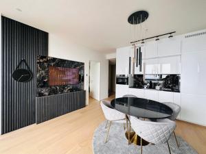 a dining room with a black and white kitchen at high-end apartment close to metro and uno-city with e-parking in Vienna
