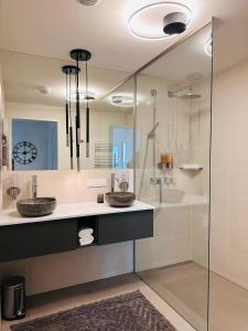 a bathroom with two sinks and a shower at high-end apartment close to metro and uno-city with e-parking in Vienna