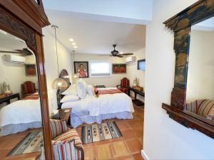 a bedroom with two beds and a mirror at Casa Culinaria - The Gourmet Inn in Santa Fe