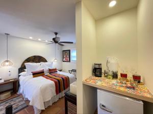 Un dormitorio con una cama y una mesa con gafas. en Casa Culinaria - The Gourmet Inn en Santa Fe