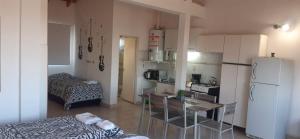 Elle comprend une petite cuisine équipée d'un réfrigérateur blanc et d'une table. dans l'établissement Ruffus's Apple Cipolletti, à Cipolletti