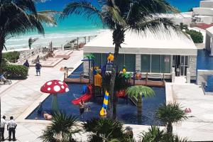 un complejo con piscina con tobogán y parque infantil en Beach, fun & relax at the Hotel Zone in Cancun en Cancún