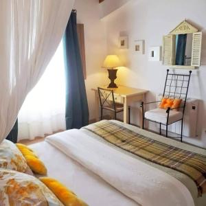 1 dormitorio con 1 cama con silla y escritorio en SeteQuintas, en Zambujeira do Mar