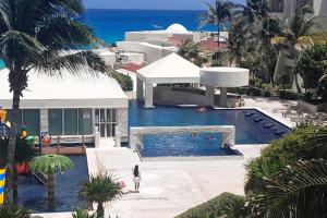 a villa with a swimming pool and the ocean at Beach, fun & relax at the Hotel Zone in Cancun in Cancún