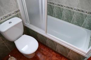 a bathroom with a white toilet and a shower at NABILA9 in Torrevieja +6 photos