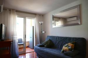 a living room with a blue couch and a mirror at NABILA9 in Torrevieja