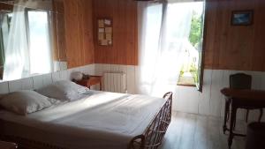 guesthouse bassin d'arcachon à la hume في غوجان-ميستراس: غرفة نوم بسرير أبيض في غرفة بها نوافذ
