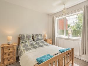 a bedroom with a large bed and a window at Ivy Cottage in Cumberworth +5 photos