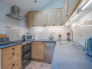a kitchen with wooden cabinets and stainless steel appliances at Walnut Cottage - Uk43995 in Fairfield