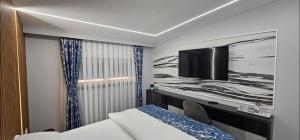 a hotel room with a bed and a flat screen tv at Luxury Room 's in Velika Kladuša