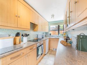 a kitchen with wooden cabinets and a counter top at Pennine View in Long Marton