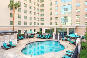 an image of a hotel pool with chairs and tables at Residence Inn by Marriott Las Vegas Hughes Center in Las Vegas