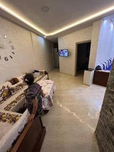 una mujer en una habitación de hotel con 2 camas en سيدي رحال الشاطئ, en Sidi Rahal