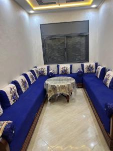 sala de estar con sofá azul y mesa en سيدي رحال الشاطئ, en Sidi Rahal