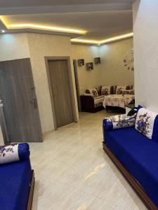 una sala de estar con un sofá azul en una habitación en سيدي رحال الشاطئ, en Sidi Rahal