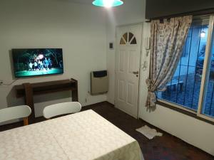 a room with a bed and a tv and a window at Casa Centro Bariloche in San Carlos de Bariloche