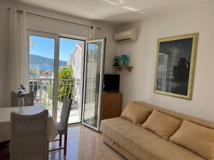 a living room with a couch and a table at Fortunella Apartments in Herceg-Novi