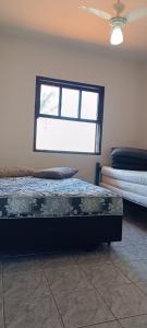 1 dormitorio con cama y ventana en Ótima casa beira mar Itapoá - SC, en Itapoa