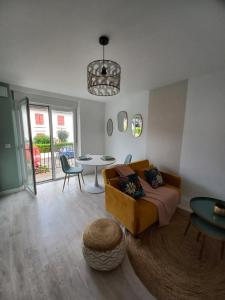 una sala de estar con un sofá y una mesa en Happiness, en Dax
