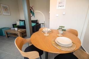 una mesa de madera con platos y sillas en la sala de estar. en Luxury Apartment in Chalkida #1, en Chalkida