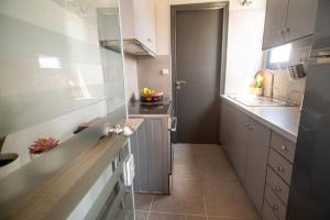 a kitchen with white cabinets and a counter top at Luxury Apartment in Chalkida #1 in Chalkida +6 photos
