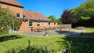 a building with tables and benches in a yard at Gudum Park in Lemvig