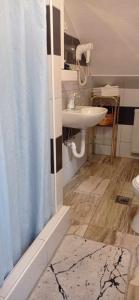 łazienka z zasłoną prysznicową i umywalką w obiekcie Holiday Home Casa Rondo w mieście Bihać