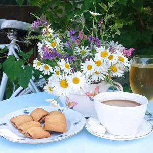 una tazza di caffè e biscotti su un tavolo con fiori di Holiday Home Casa Rondo a Bihać