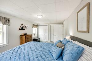 ein Schlafzimmer mit einem großen Bett mit blauer Bettwäsche in der Unterkunft Chic and Central Apartment about 6 Mi to Sebec Lake! in Dover-Foxcroft