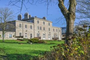 an old house with a tree in front of it at 9 Admiralty House Stunning Luxury Apartment with free parking in Plymouth