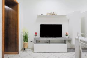 a living room with a tv on a white wall at Saint Simplicio House in Olbia