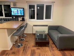 a living room with a couch and a table at London flat next to DLR station with free parking in London