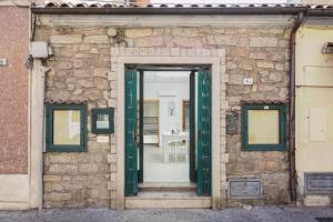 an open door in a stone building with a staircase at Saint Simplicio House in Olbia