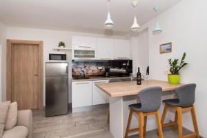 eine Küche mit weißen Schränken und einem Tisch und Stühlen in der Unterkunft Apartments Galic in Šibenik