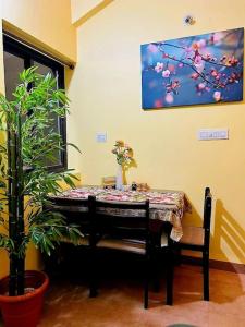 einen Tisch in einem Raum mit einem Tisch und einer Pflanze in der Unterkunft Reev's Homestay: Luxury 2 Bedroom apartment in Arossim-Cansaulim