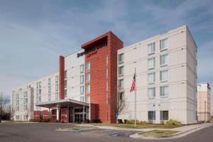 an office building with an american flag in front of it at SpringHill Suites by Marriott Salt Lake City Airport in Salt Lake City