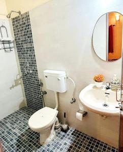 a bathroom with a toilet and a sink at Reev's Homestay: Luxury 2 Bedroom apartment in Arossim-Cansaulim