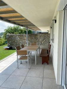 een patio met een tafel en stoelen en een stenen muur bij Apartment Kaapi in Friedrichshafen