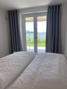 een slaapkamer met een bed en een groot raam bij Apartment Kaapi in Friedrichshafen