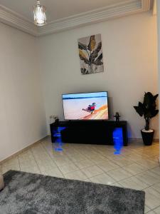uma sala de estar com uma televisão de ecrã plano na parede em Appartement luxueux à Agdal près de la gare em Rabat