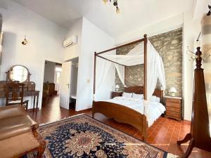 a bedroom with a canopy bed and a living room at Anamar Symi Residences in Symi