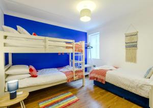 a bedroom with two bunk beds and a blue wall at Sea Glass in Swanage