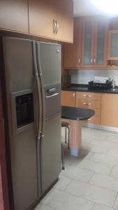 a kitchen with a stainless steel refrigerator and a table at Room at the Sky in Panama City